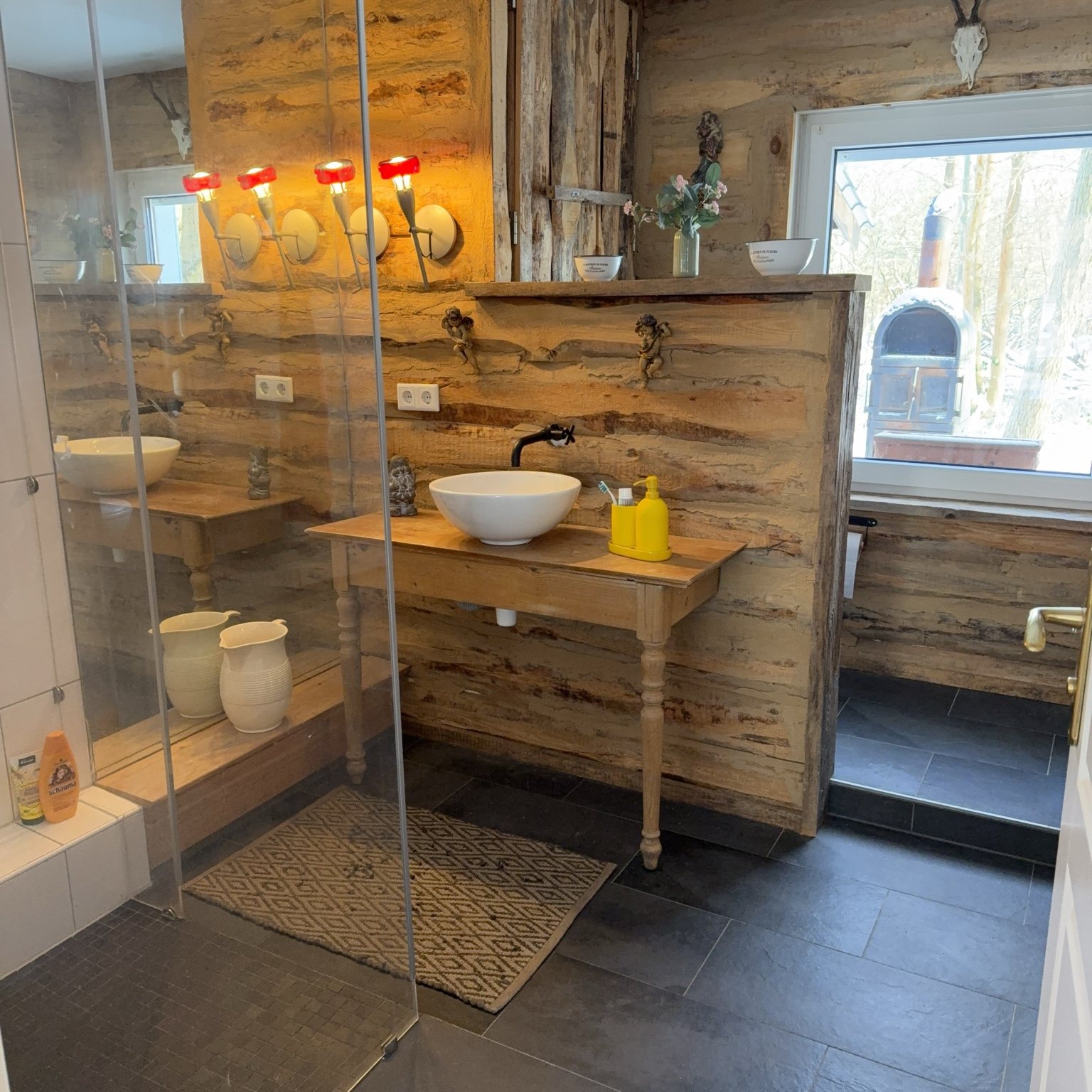 Badezimmer mit Glasabtrennung und rustikalem Holz-Wanddesign