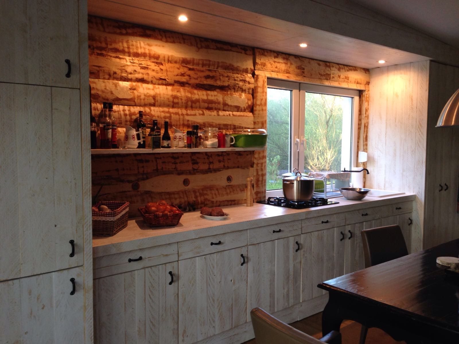 Küche mit rustikaler Holzwand und Holzeinbauten